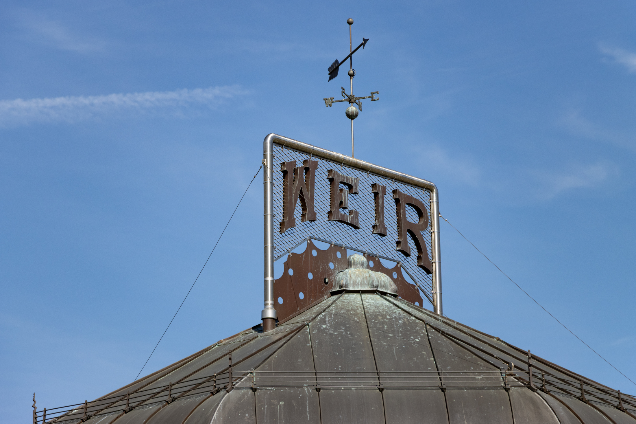the weathervane and the weir sign on top of the restored greenhouse