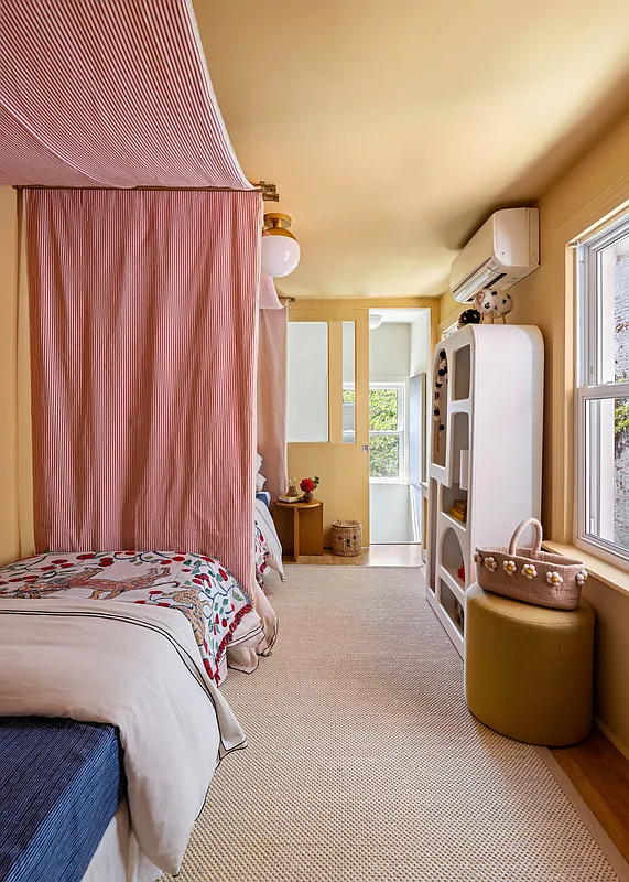 narrow bedroom with yellow walls and door to staircase