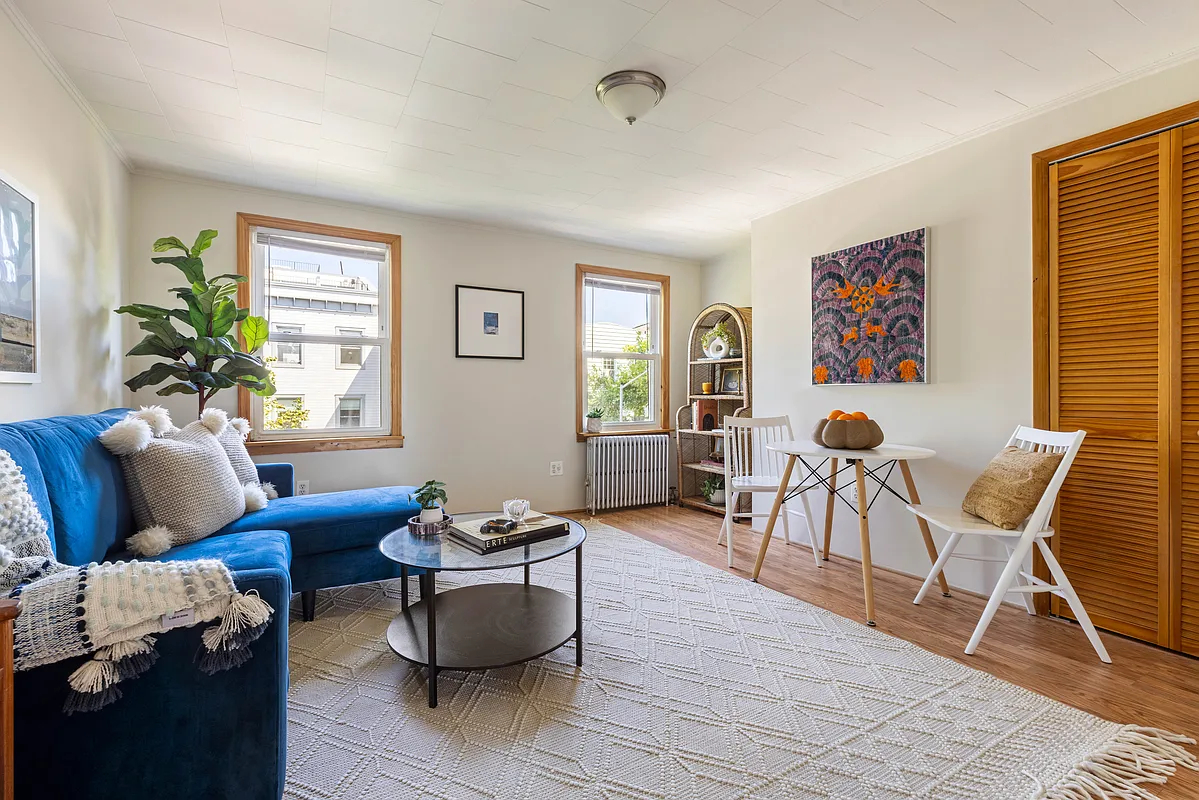 living room with two windows, closet with louvered doors