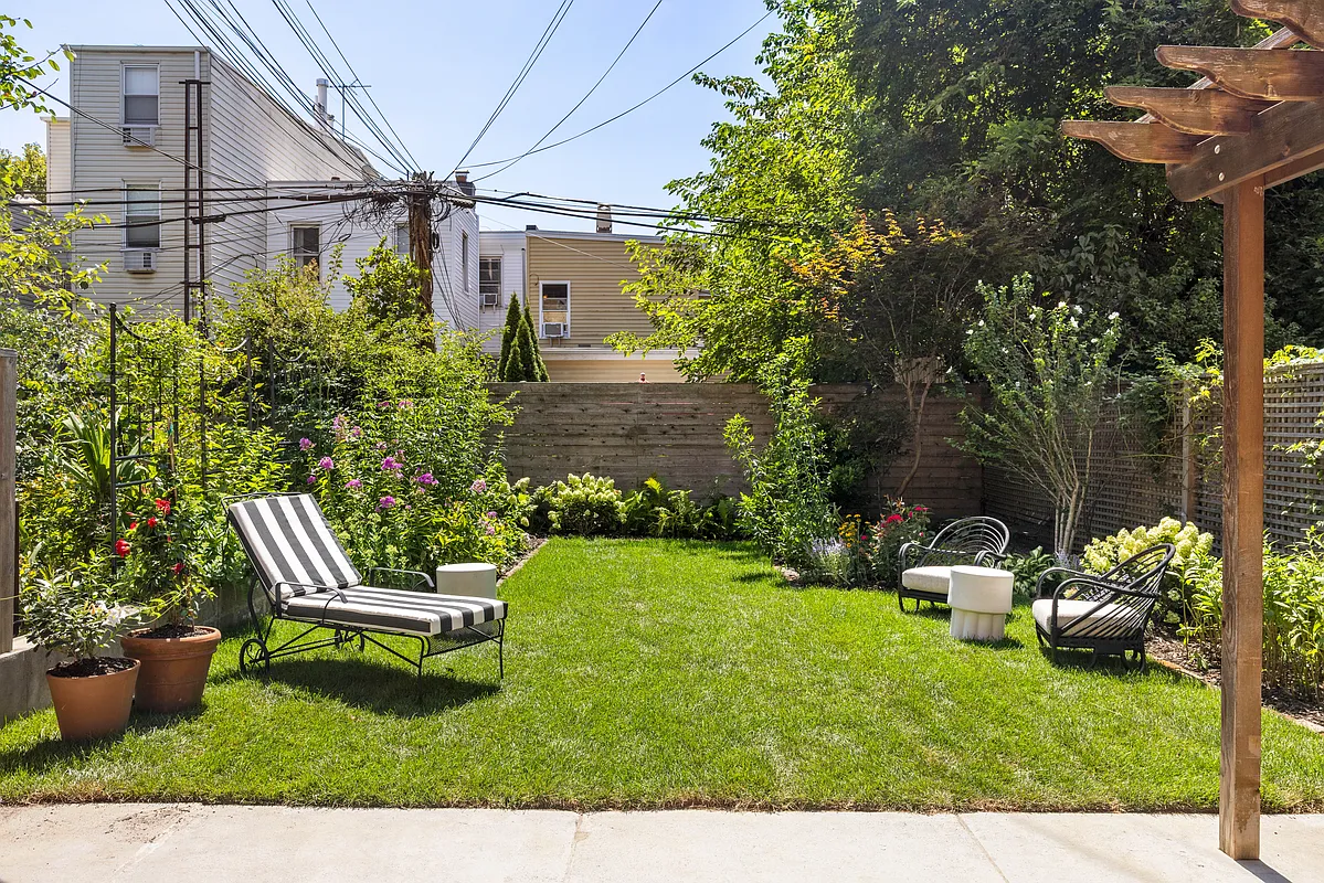 rear yard with a bit of lawn ringed by planting beds