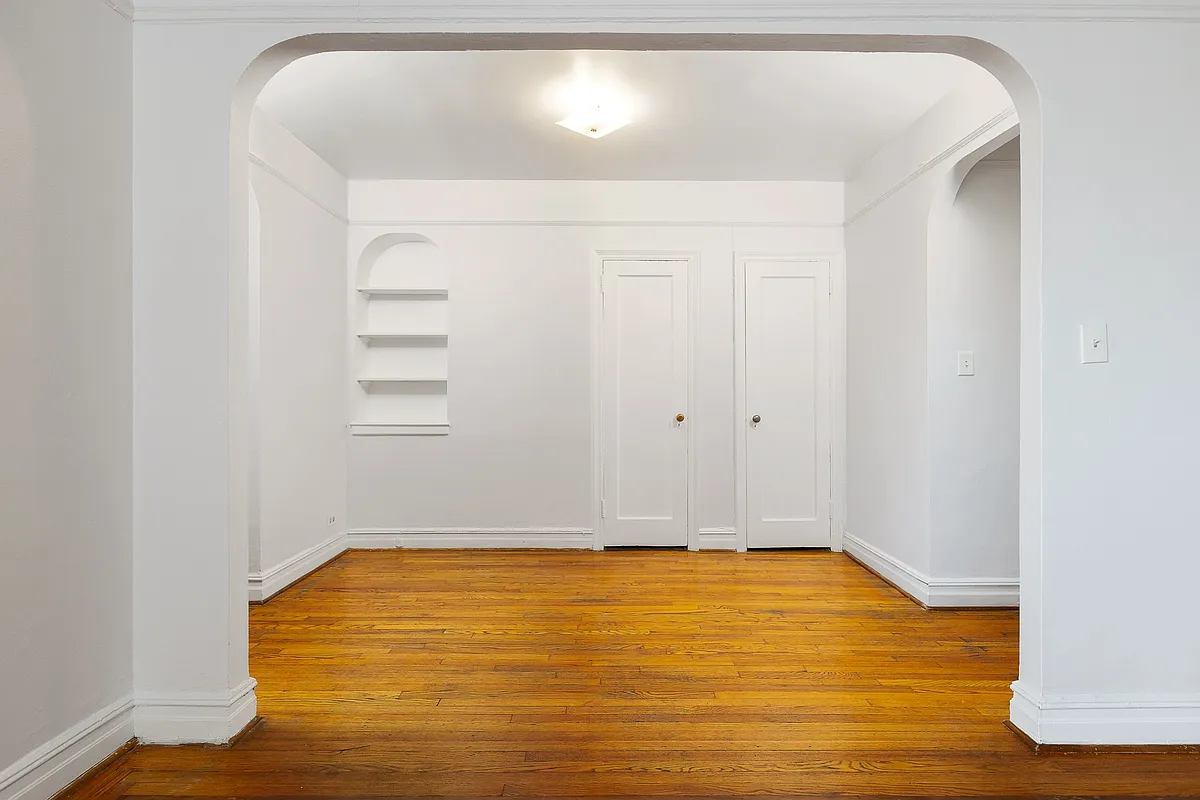 foyer with two closets, a niche with shelves