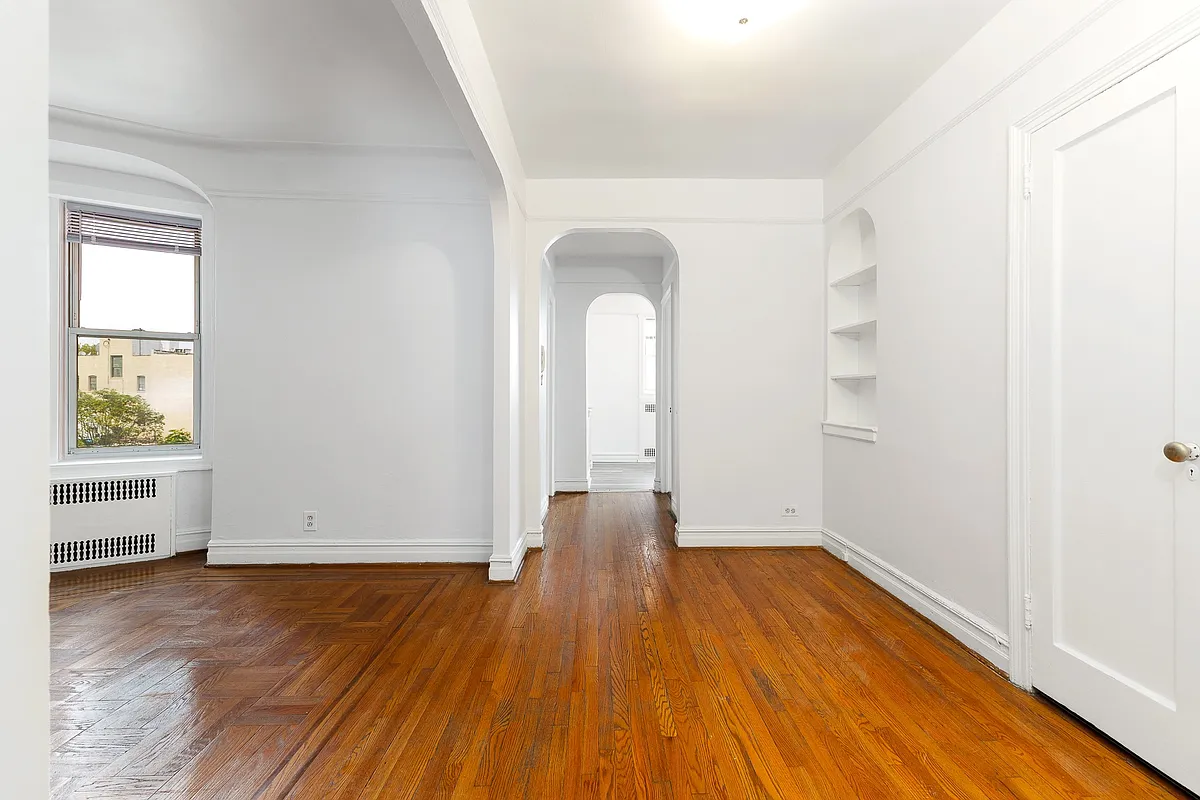 foyer with wood floor, niche with shelves, picture rails