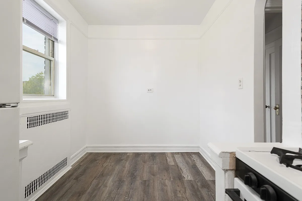 dining nook with faux wood floor, white walls, picture rail
