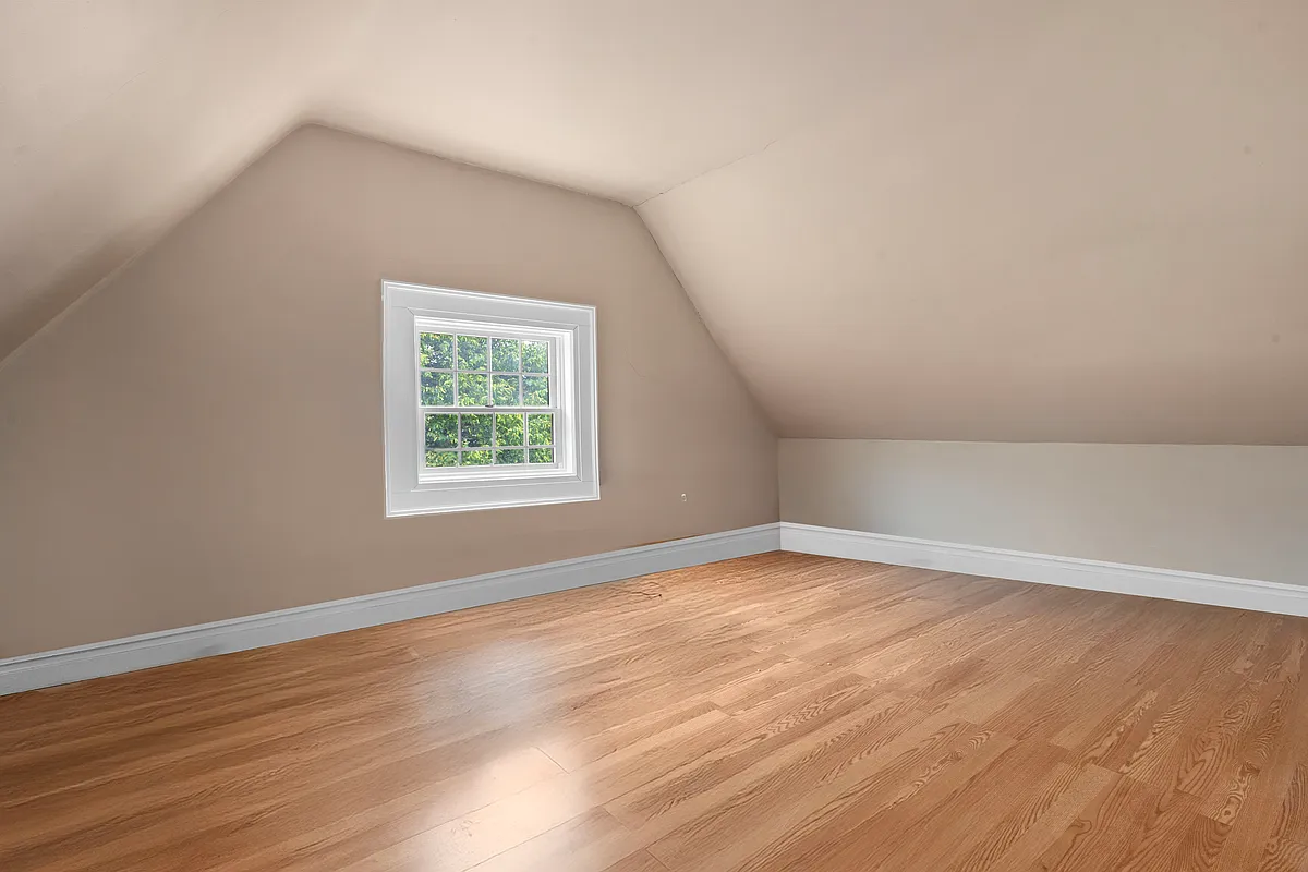 bedroom with beige walls, wood floor