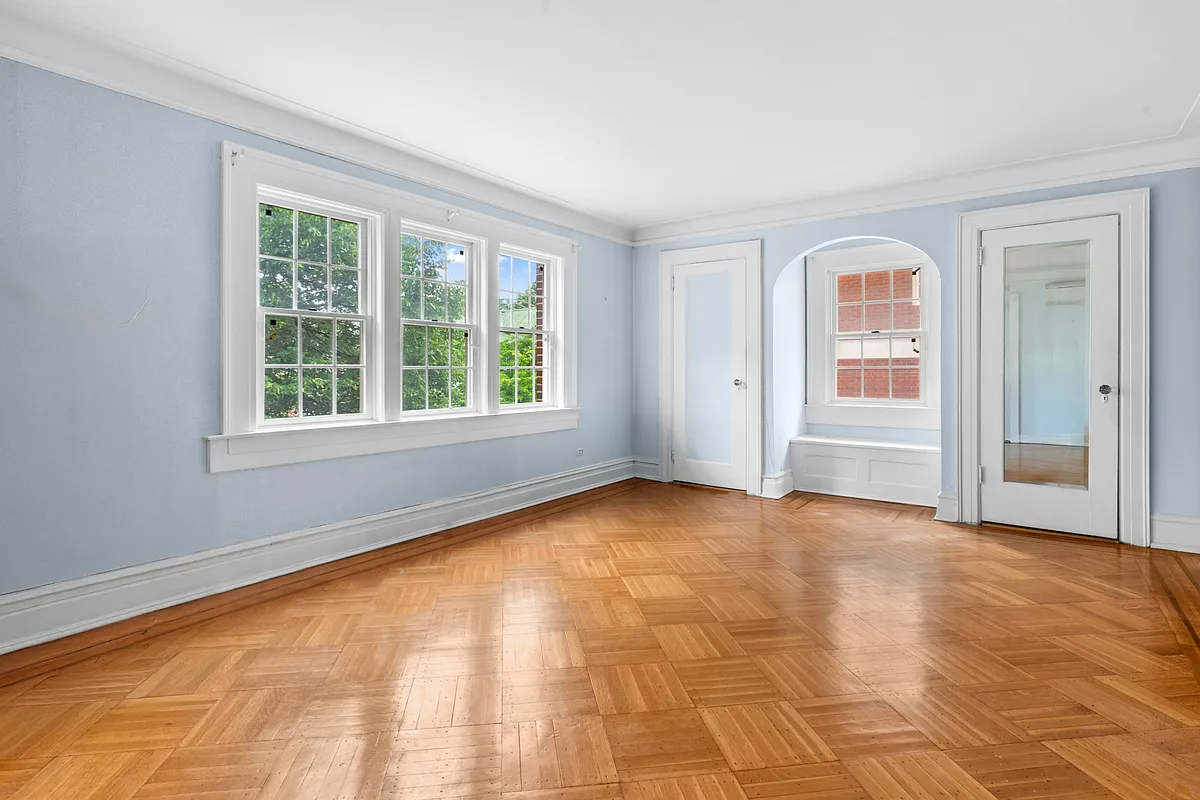bedroom with blue walls, wood floor, window seat