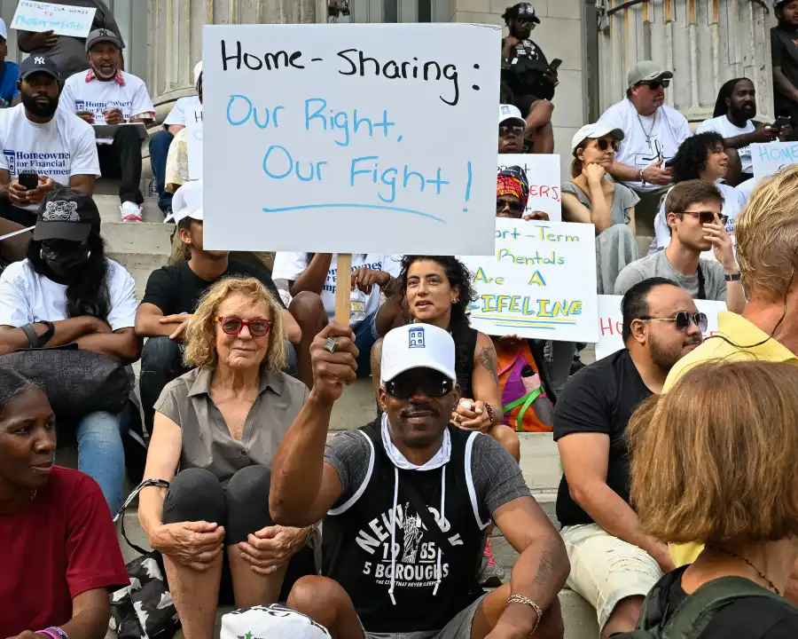 homeowners at a rally holding protest signs