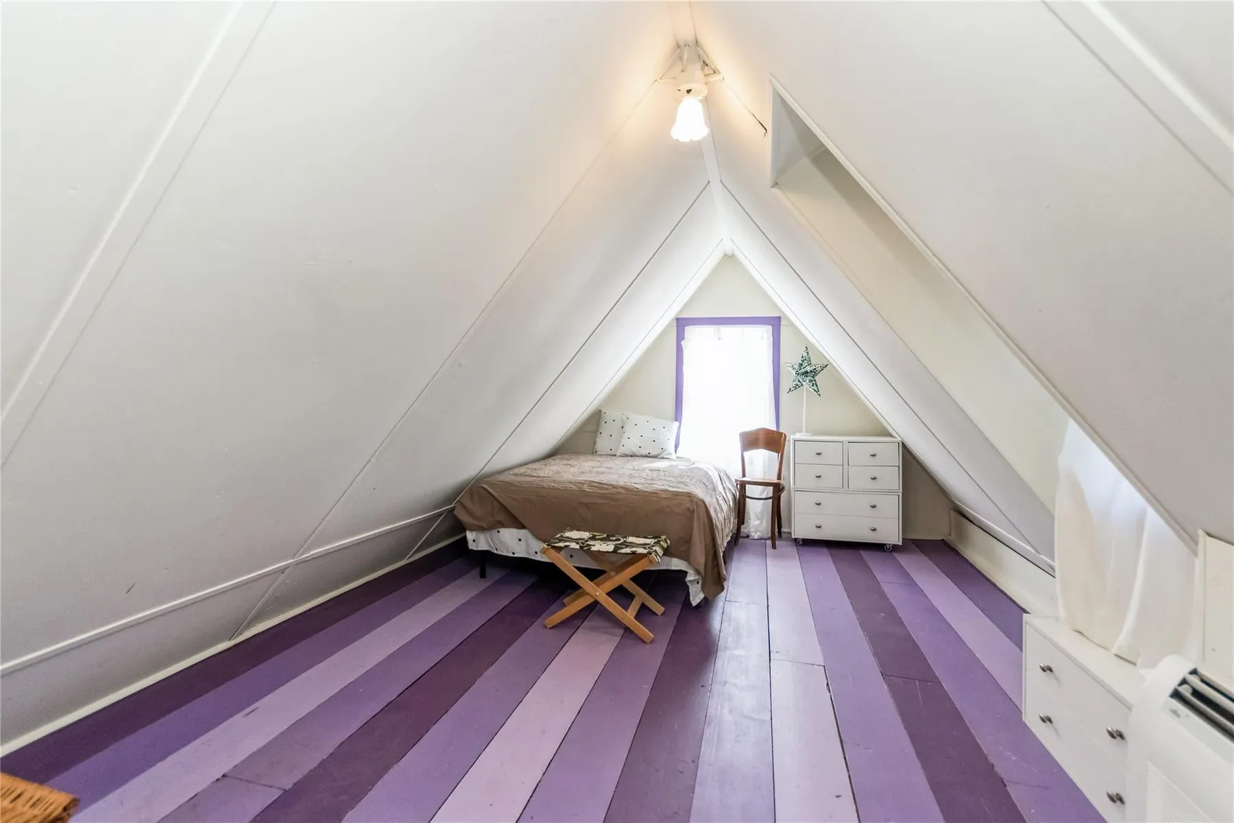 bedroom in the gable with an angled ceiling and a floor painted in shades of purple