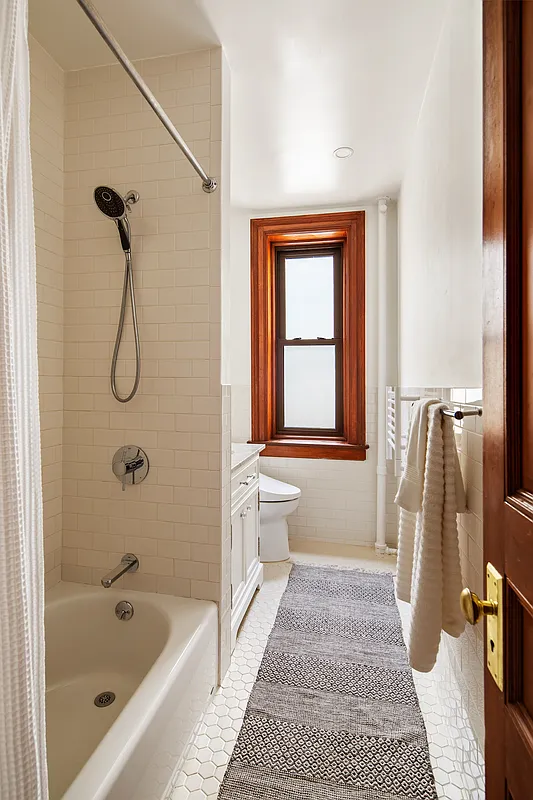 bathroom with tub and white subway tile on the walls