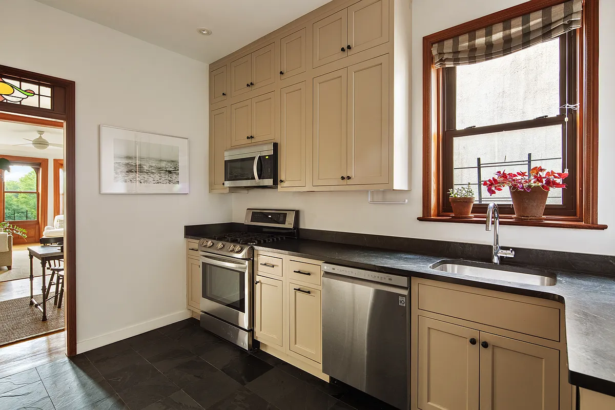 kitchen with cream cabinets, black counter, and stainless steel appliances