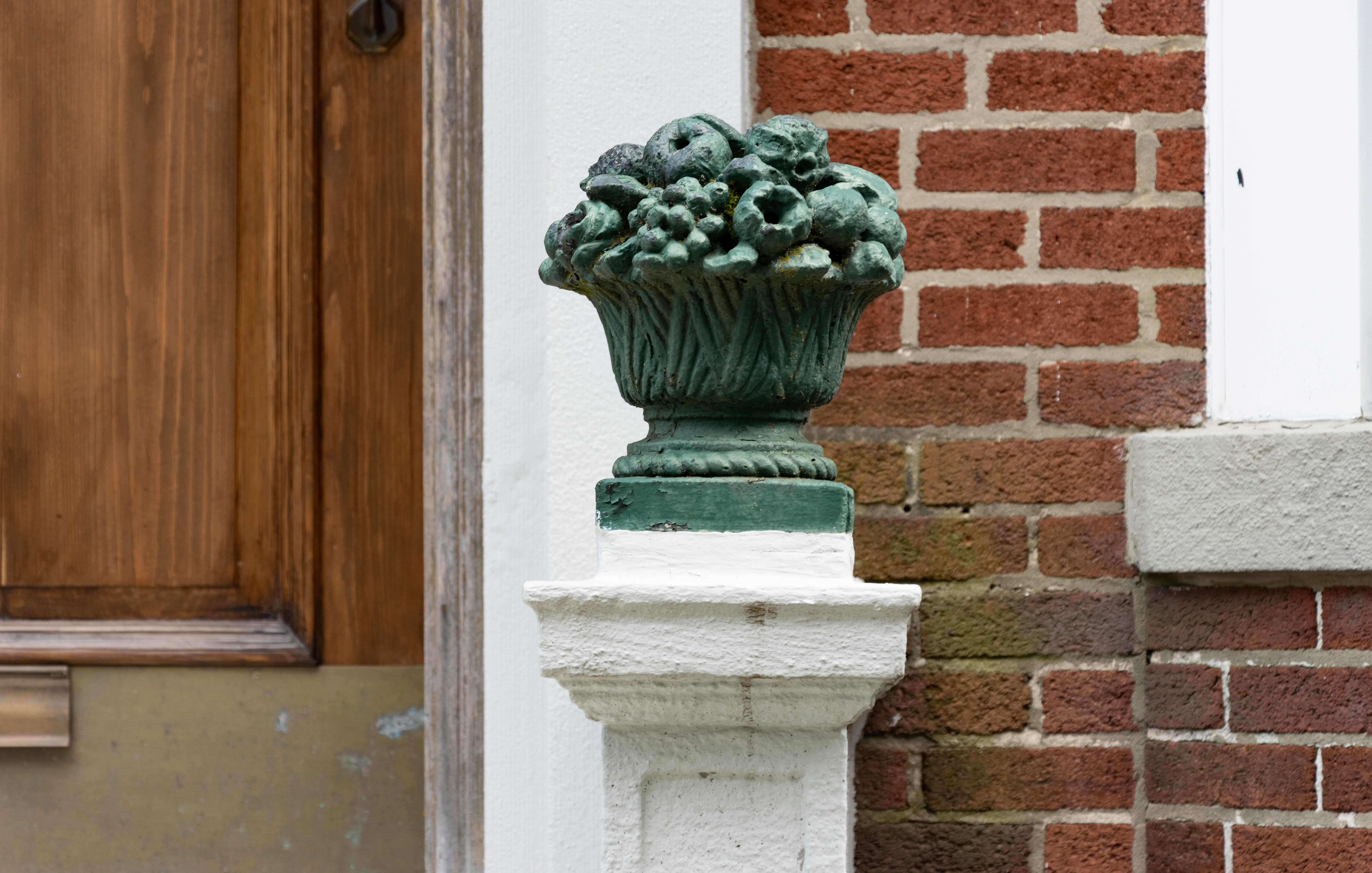 a metal fruit basket adorning a stoop