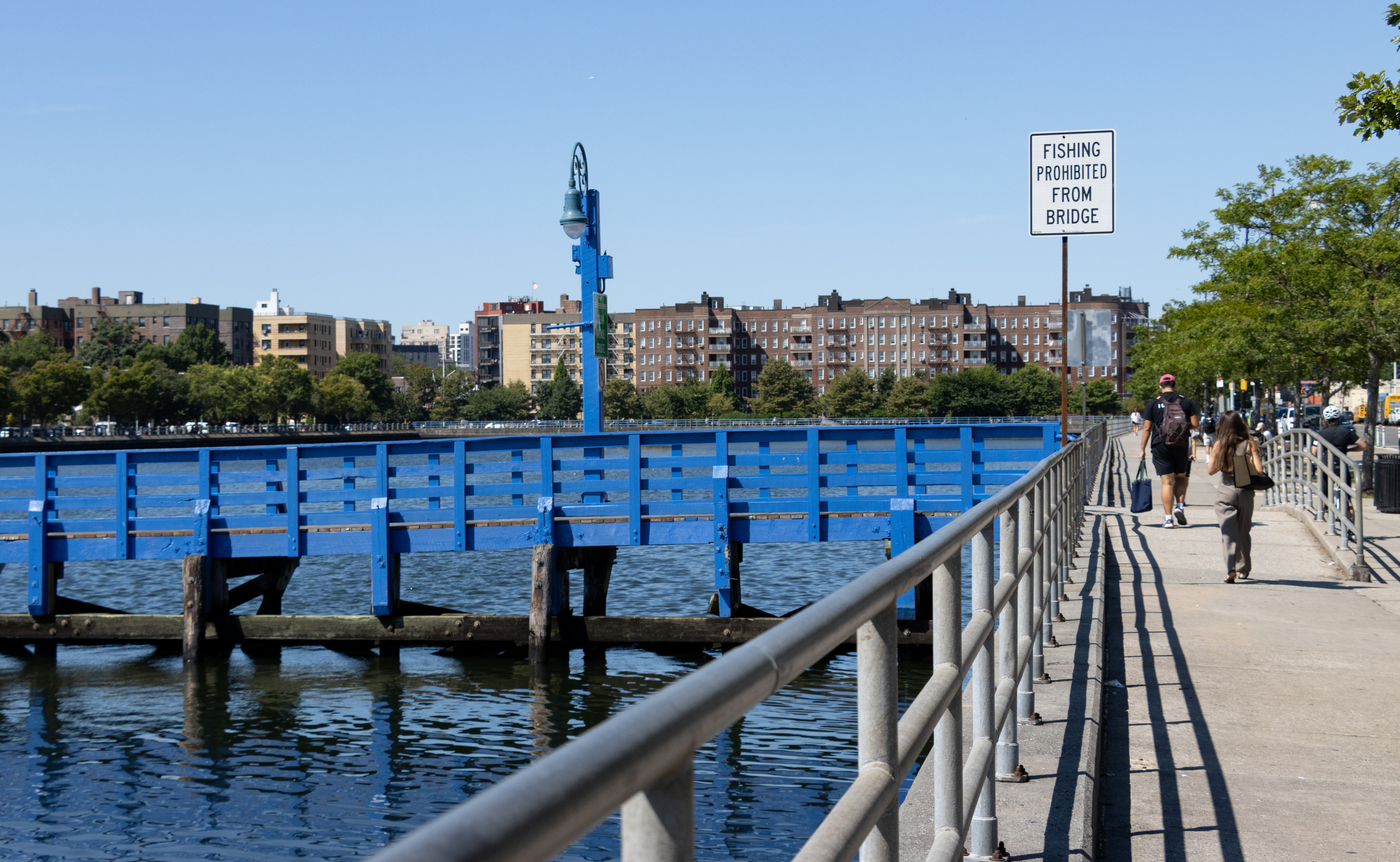 the boardwalk along the water leading to the blue bridge