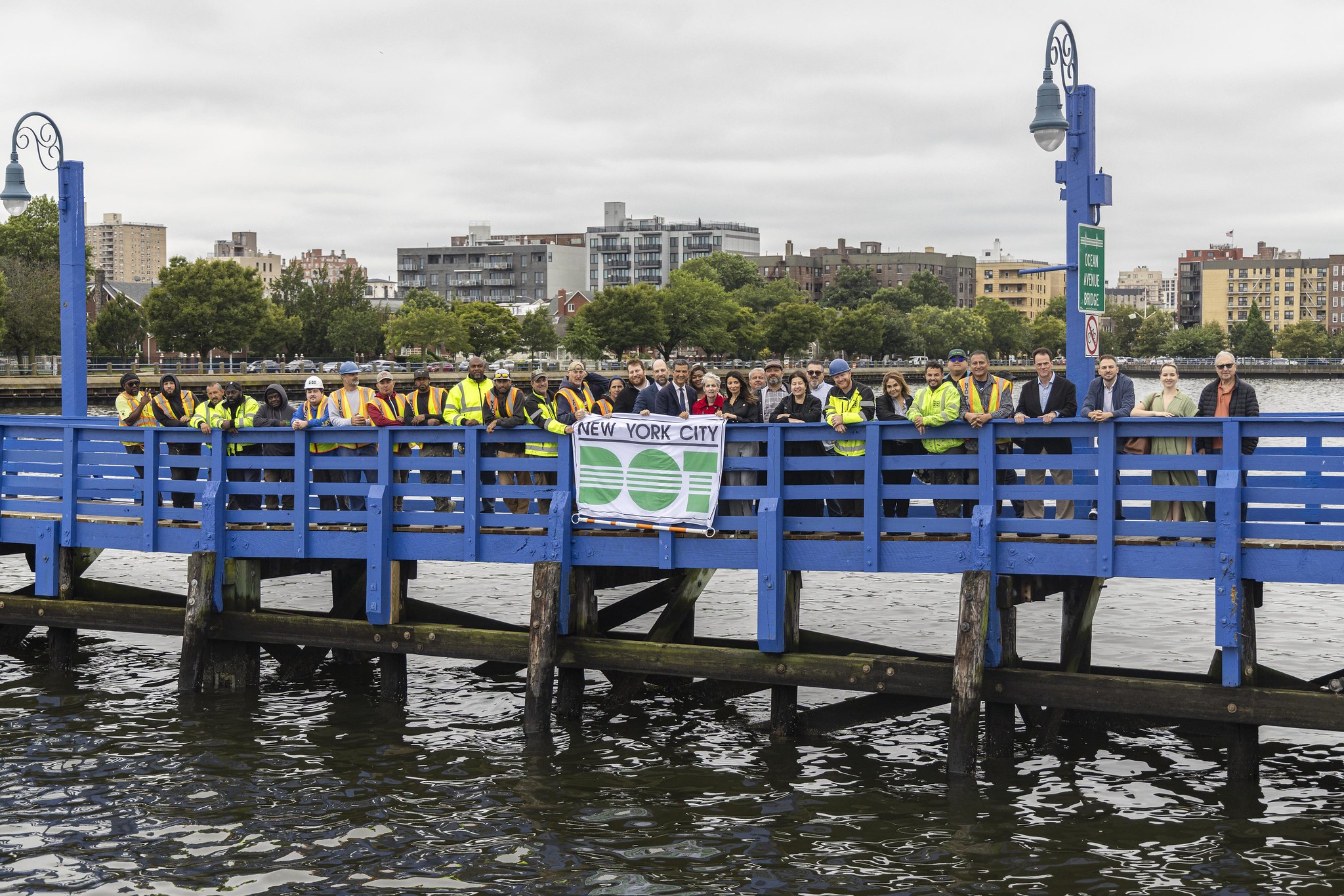 group posing on the bridge with a dot banner
