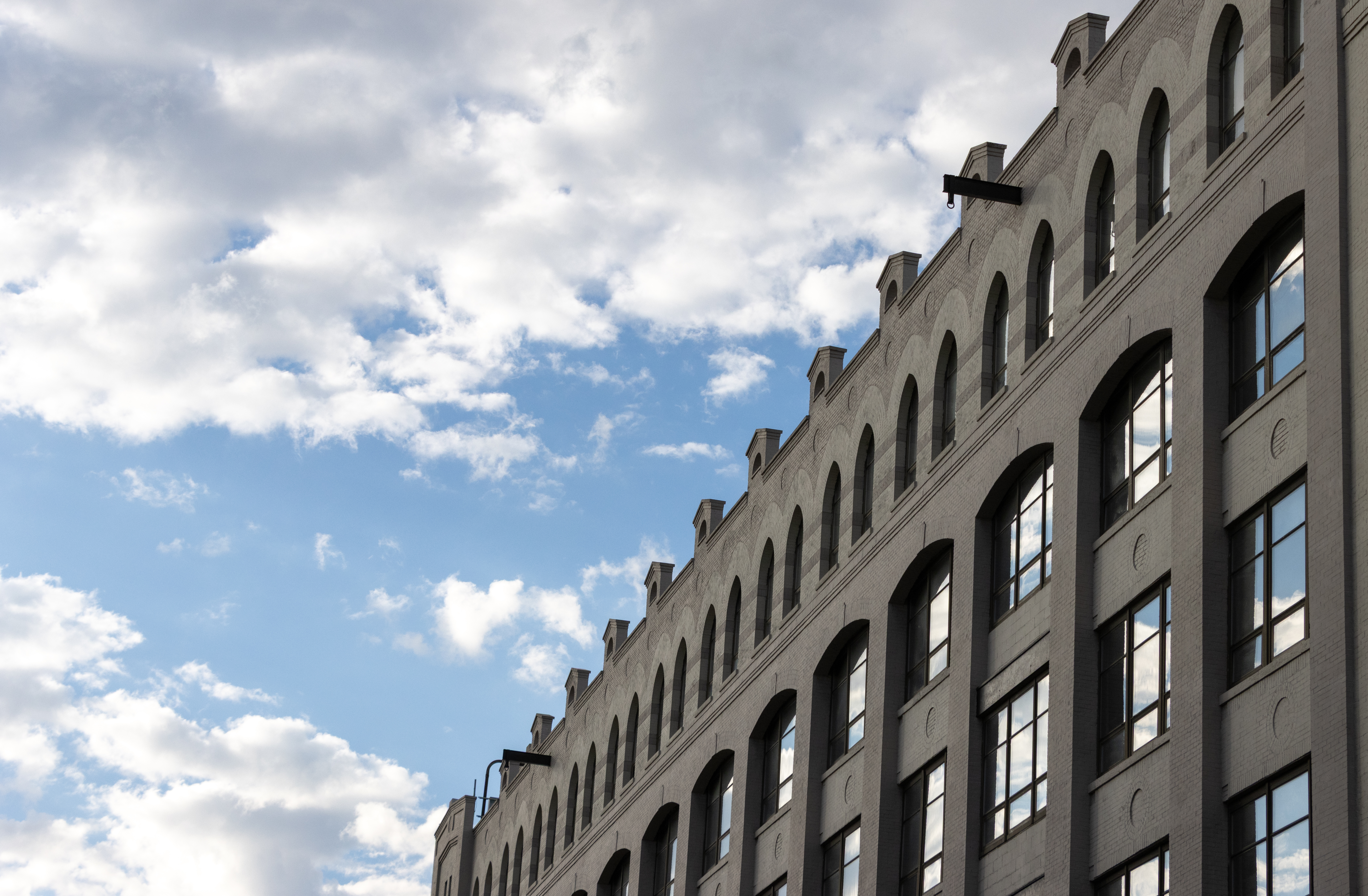 cloudy sky reflected in the windows of industry city brick building