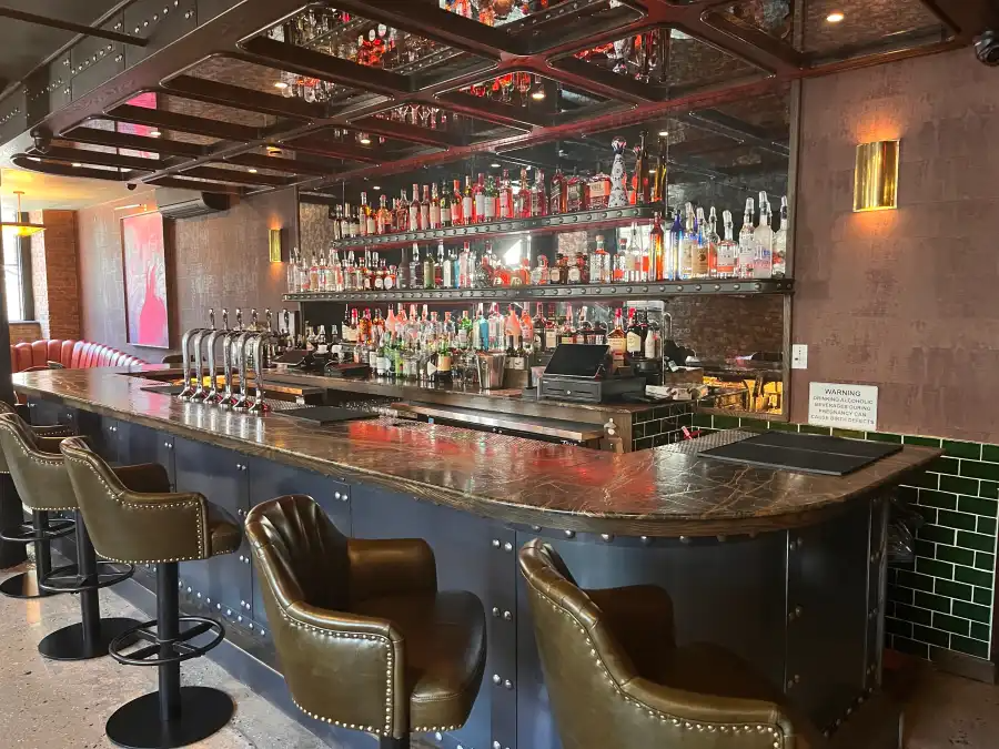 bar with green leather stools with backs