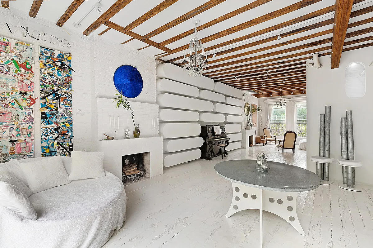white interior with a mantel, beamed ceiling
