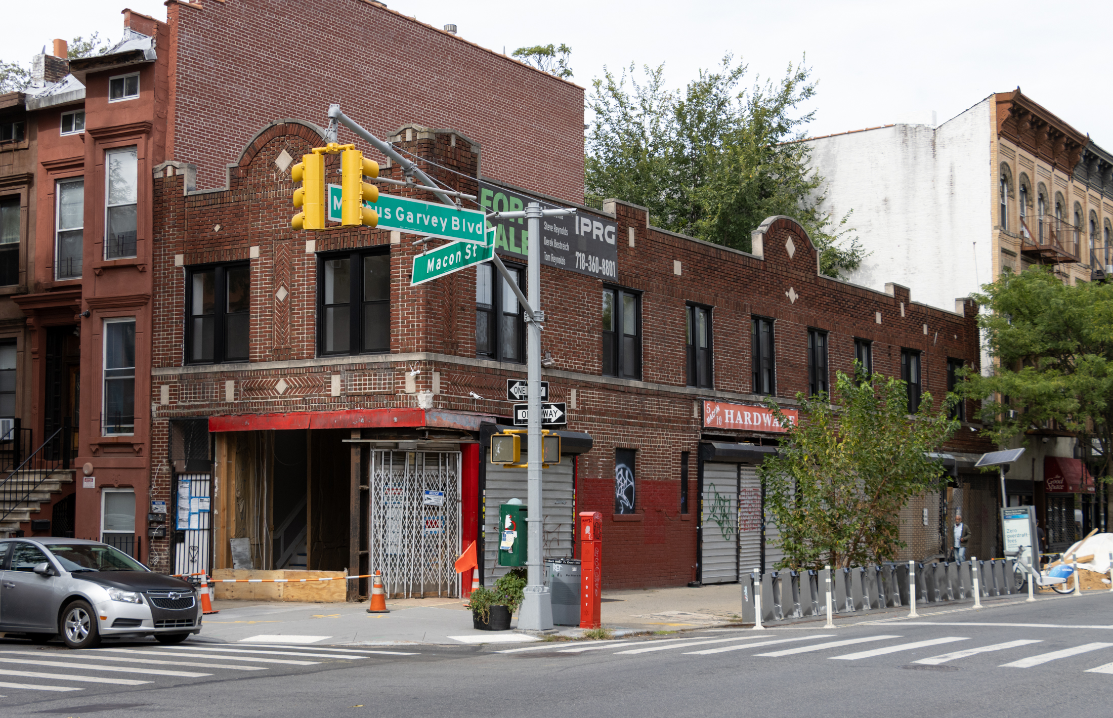 brick building on a corner with safety cones around the entrance