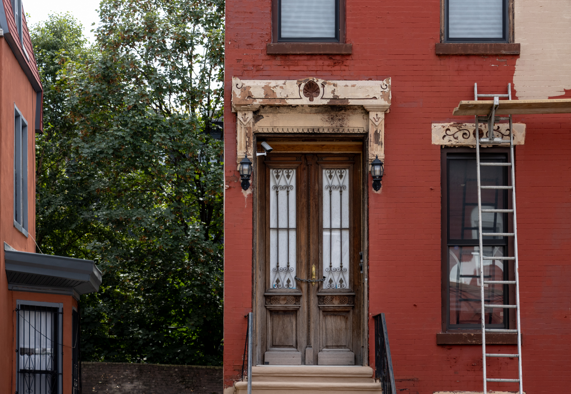 brick row house with a ladder against it