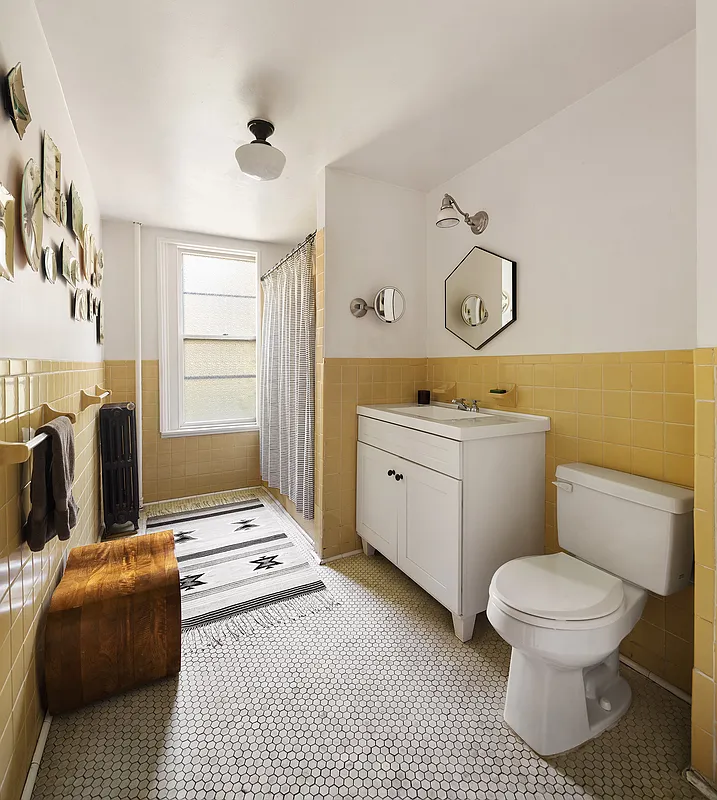 bathroom with yellow wall tiles, white hex floor tiles