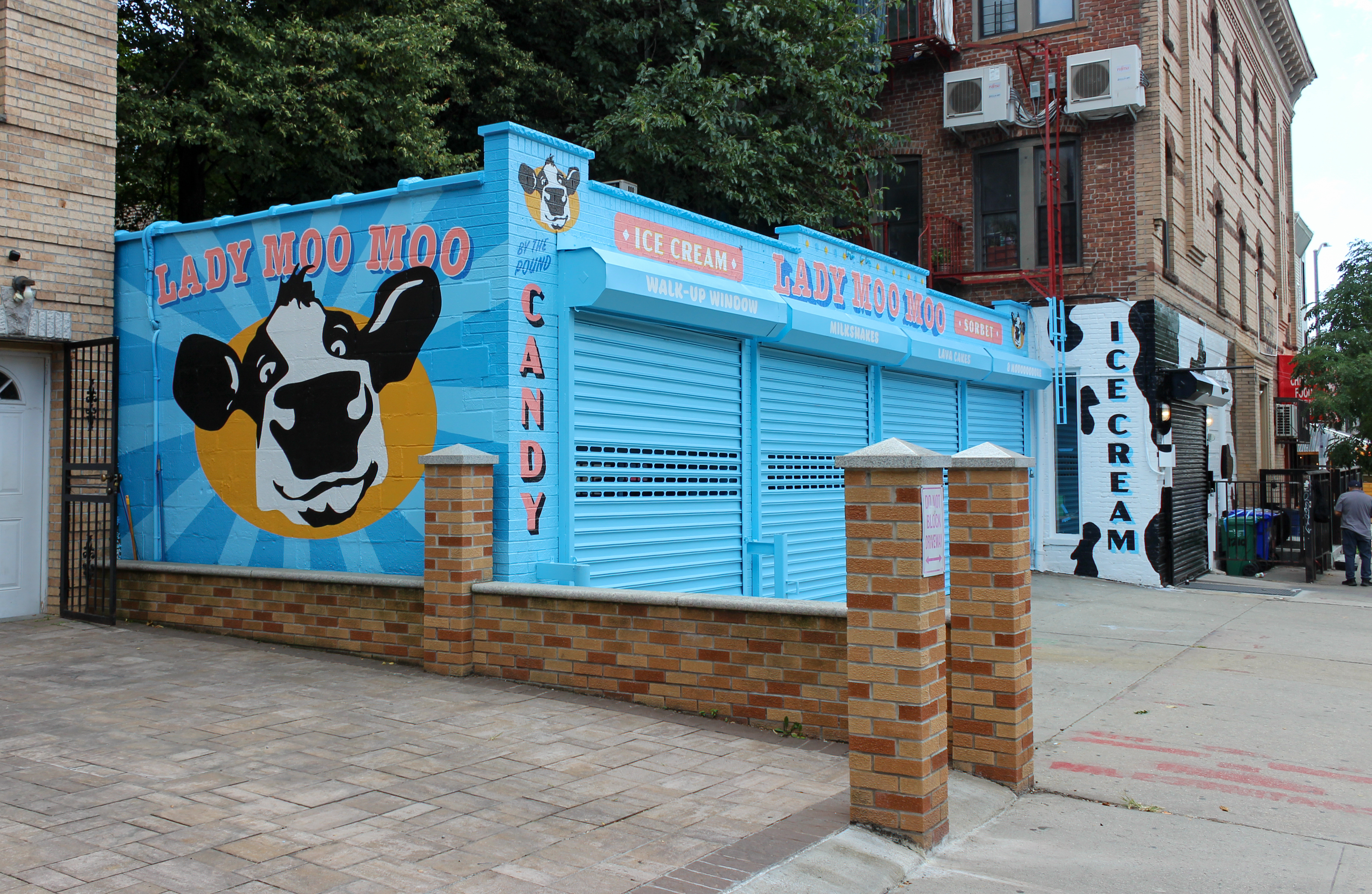 one story building painted blue with a cow on the side