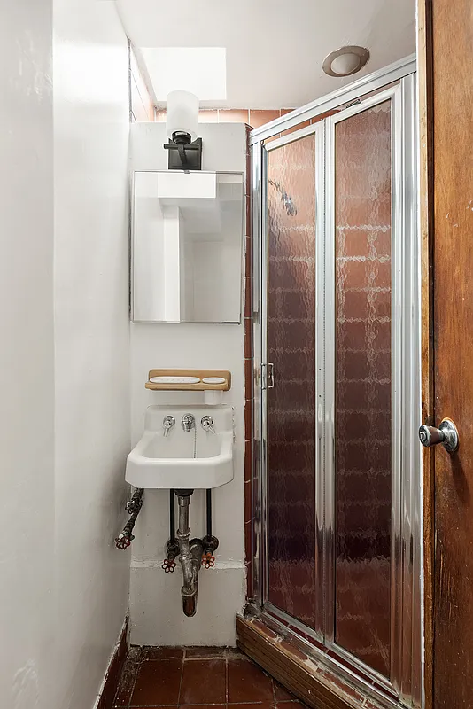 bathroom with corner shower, tiny wall mounted sink