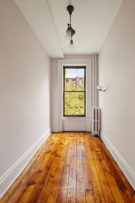 narrow bedroom with wood floor