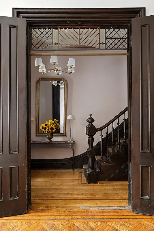 view through parlor doorway with fretwork into the entry hall