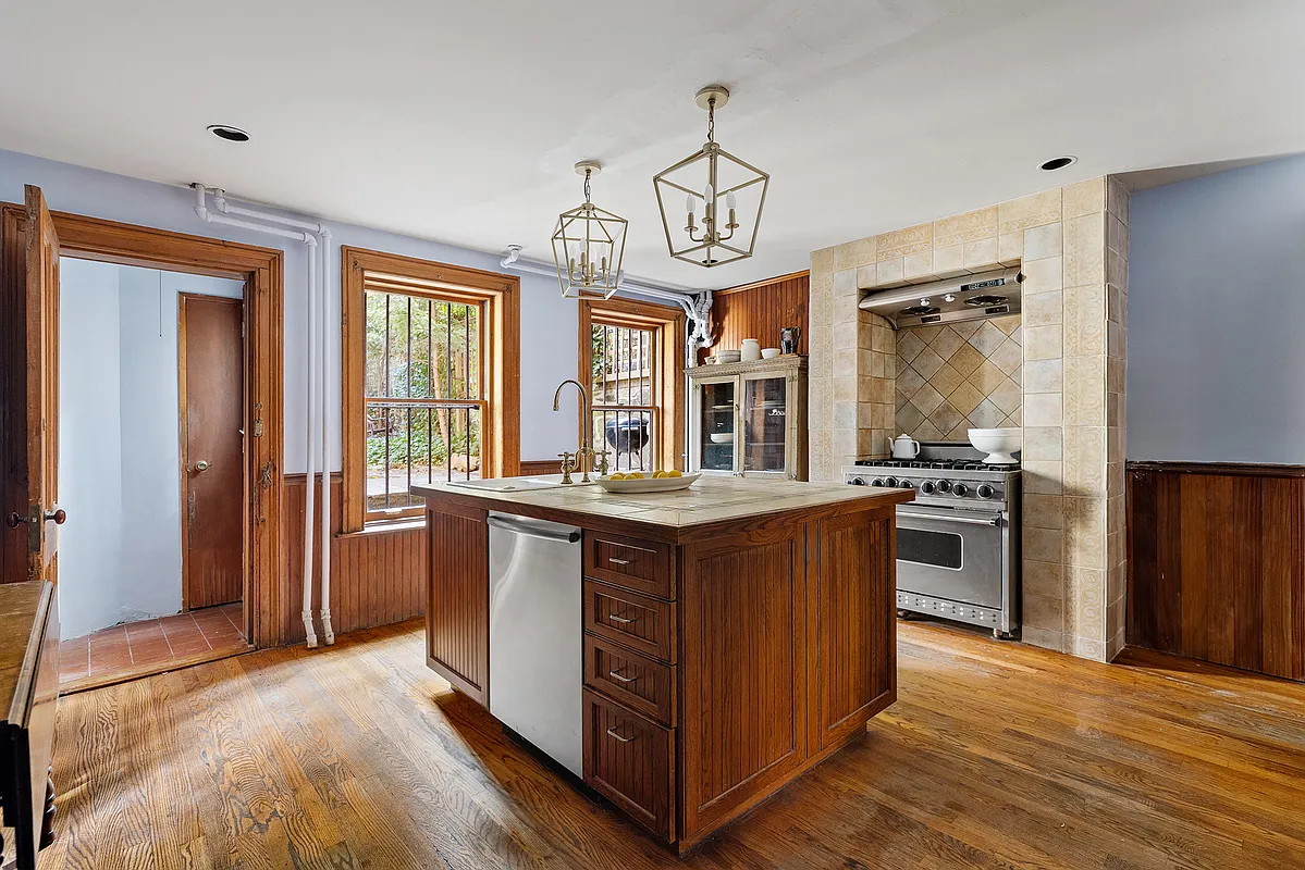 kitchen with wainscoting, a center island with dishwasher, and a wood floor