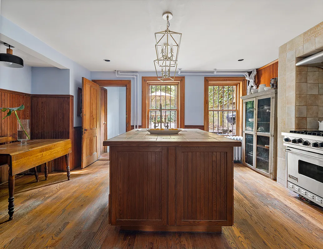 kitchen with center island, tiled stove nook and wood floor