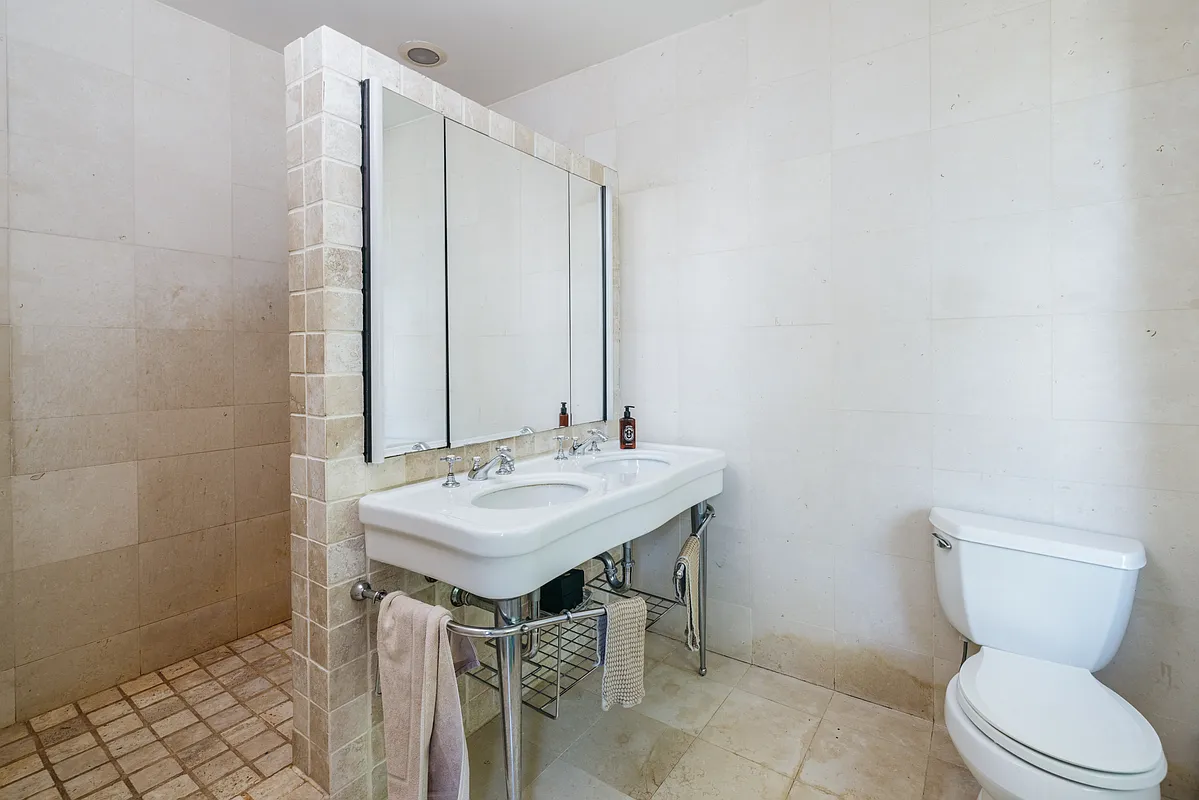 bathroom with a double vanity and a walk-in shower