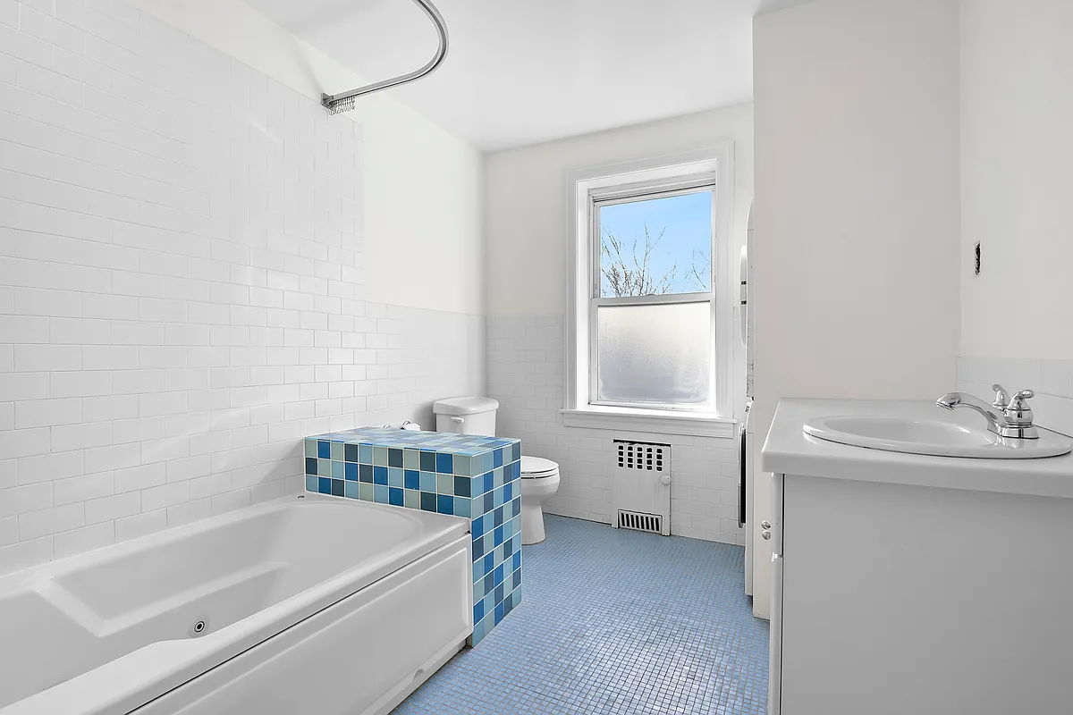 bathroom with light blue mosaic floor, white fixtures