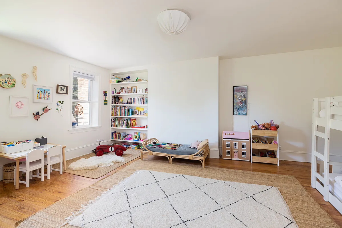 bedroom with white walls, room for bunkbeads and a play area