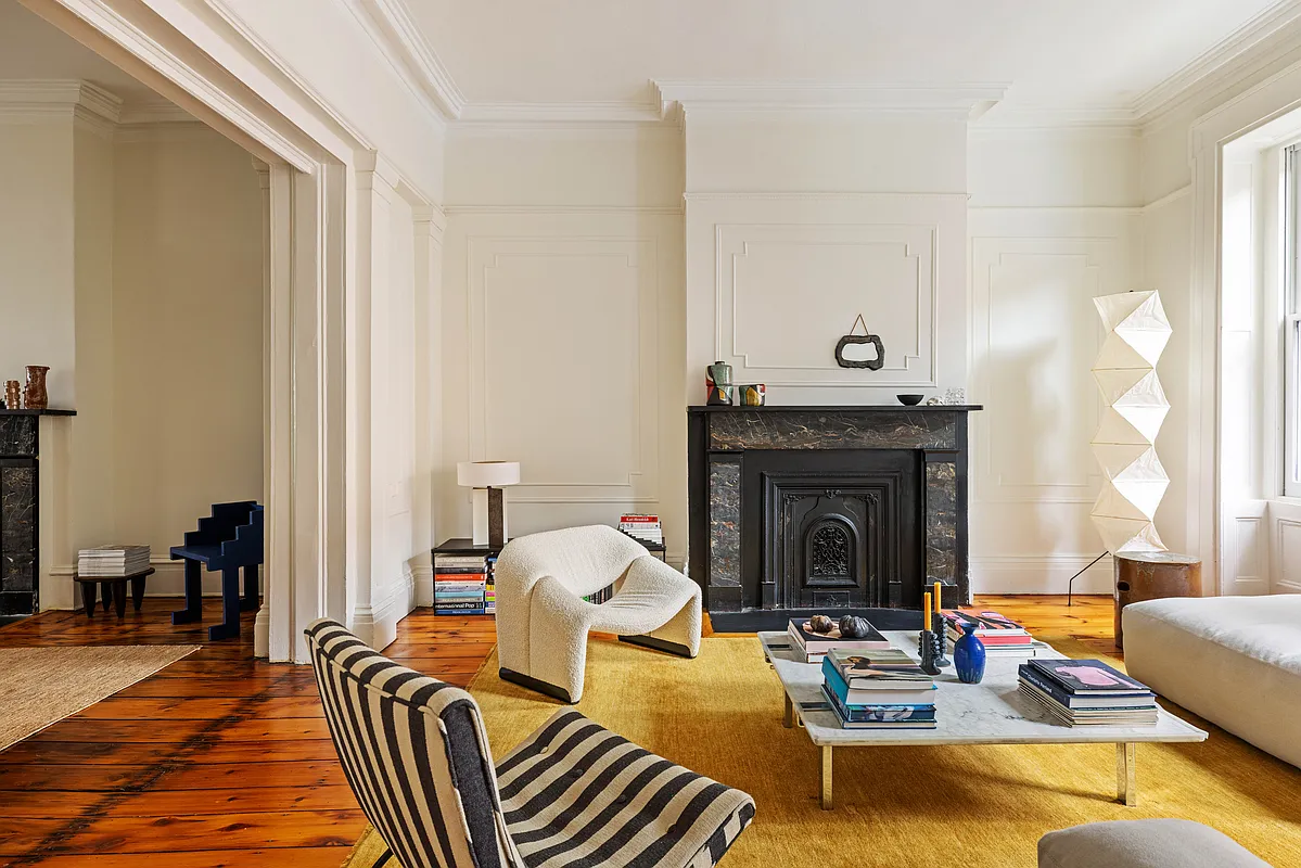 parlor with wood floor, wall moldings, black marble mantel