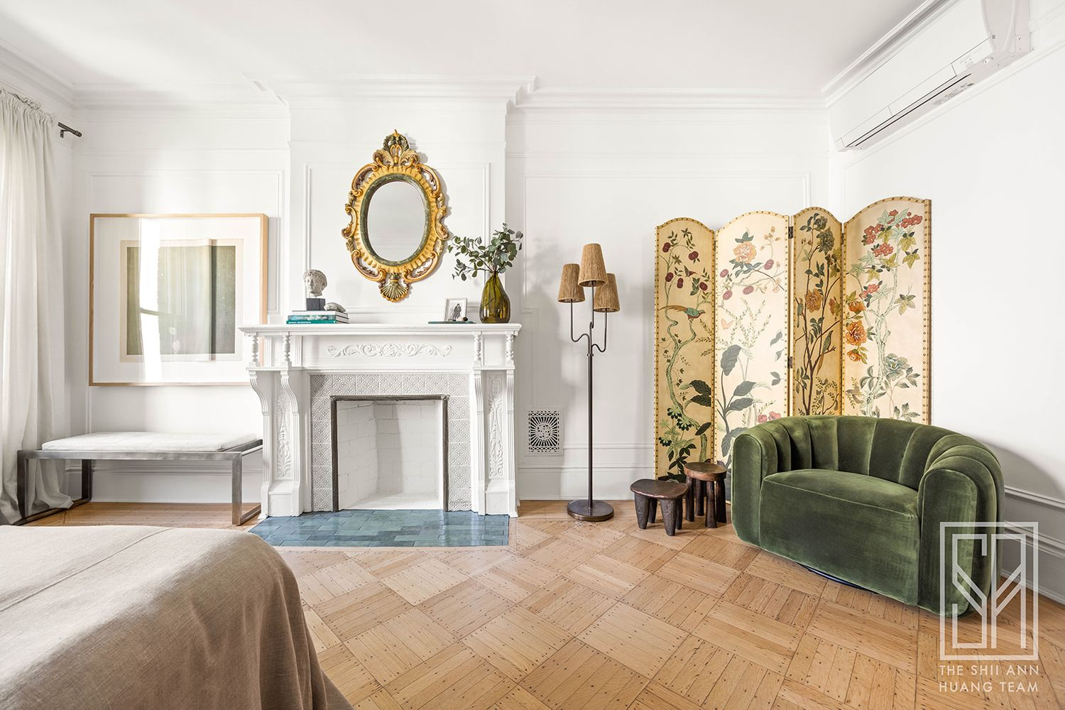 bedroom with wood floor, white mantel, mini split visible