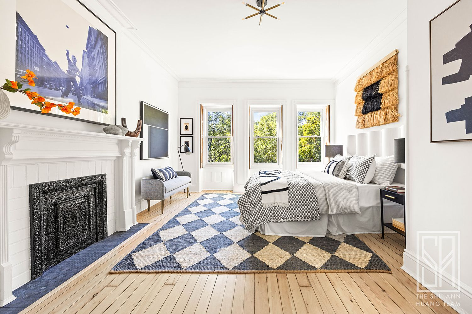 bedroom with three windows, interior shutters, white mantel