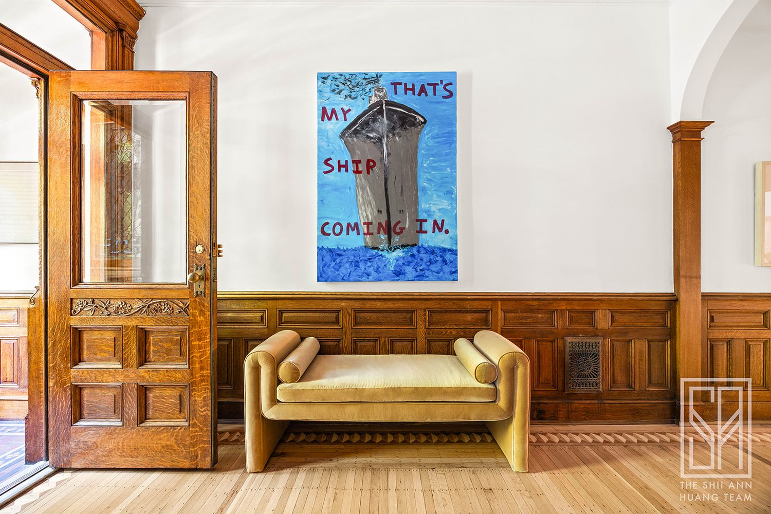 entry with wainscoting, original door, and wood floor