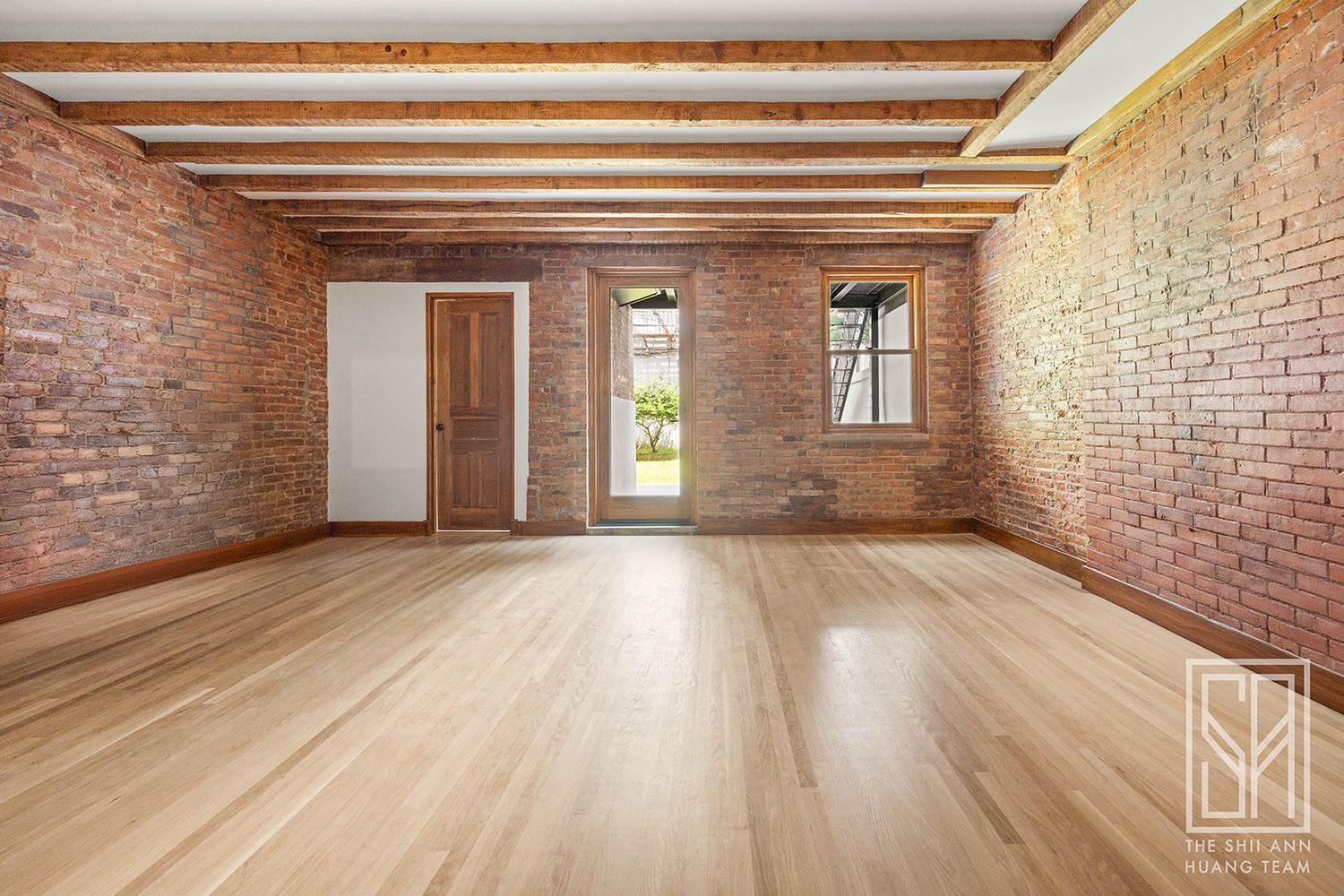 garden level apartment with exposed brick walls, glass door to rear yard