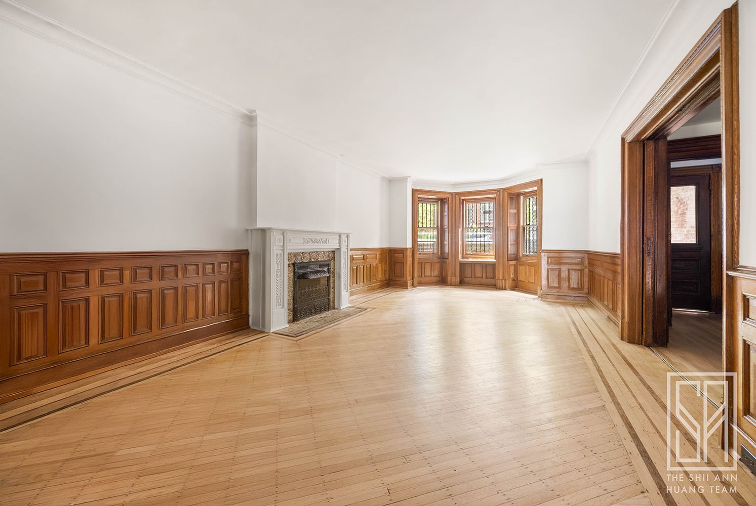 former dining room on garden level with wainscoting, mantel, wood floor