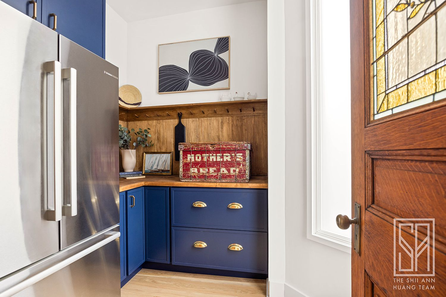 pantry with blue cabinets and the fridge