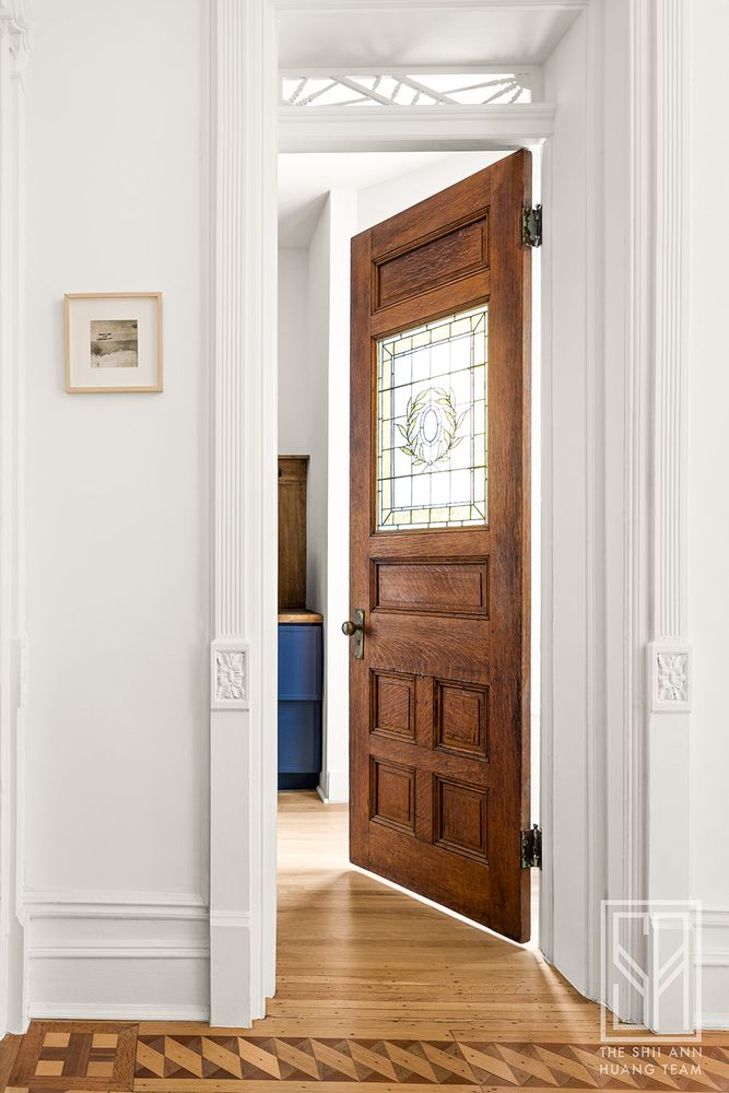 a door with stained glass window opens into the pantry