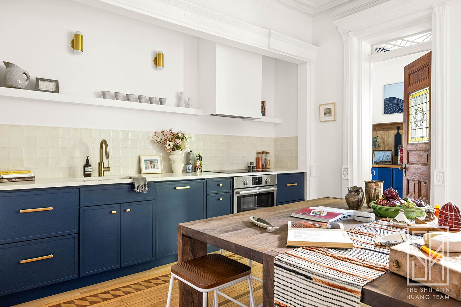 open plan kitchen and dining with blue lower cabinets and white walls