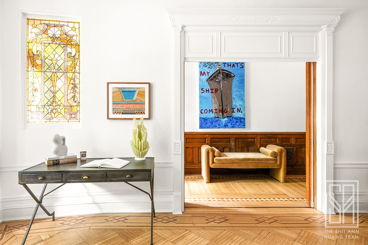 view from parlor into entry with moldings and wood floors