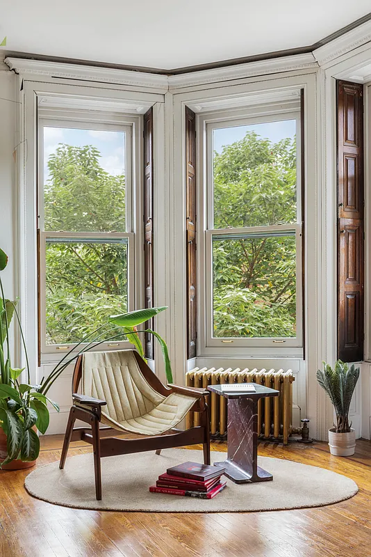 bedroom with interior shutters, wood floor