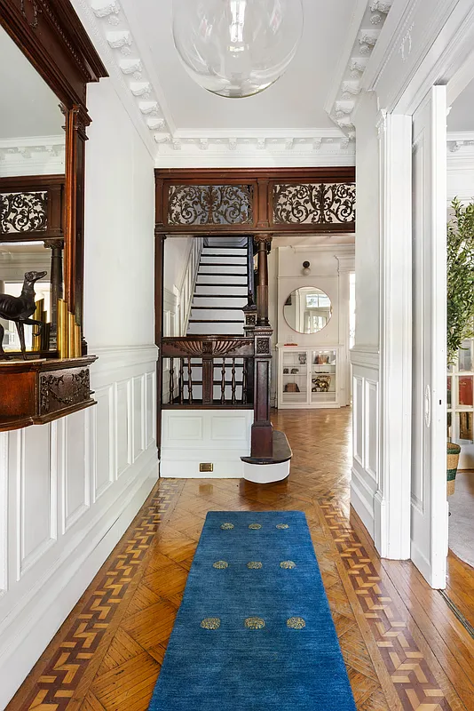 entry hall with wainscoting and a fretwork screen in front of staircase