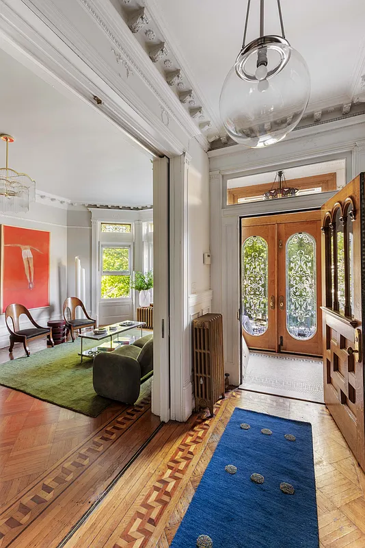 entry hall with plasterwork, wood floor and wood front door