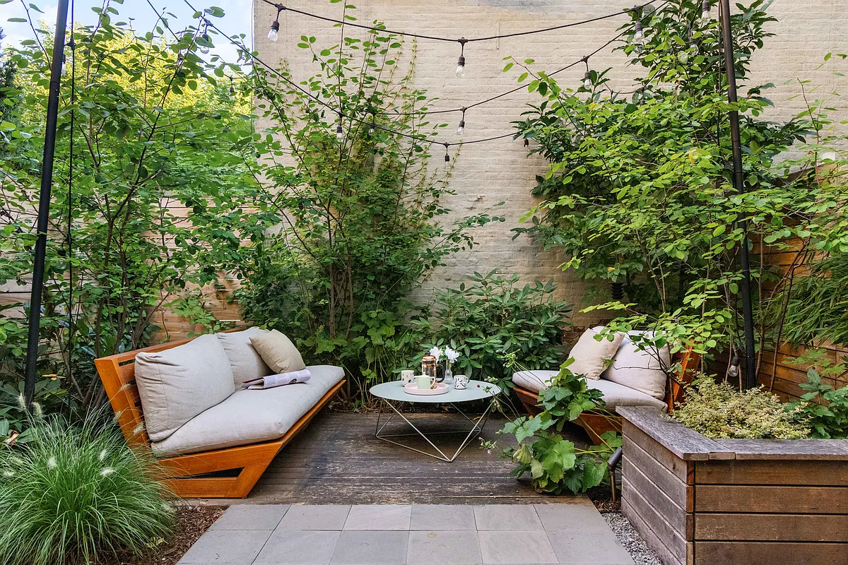 rear yard with seating area surrounded by planting beds