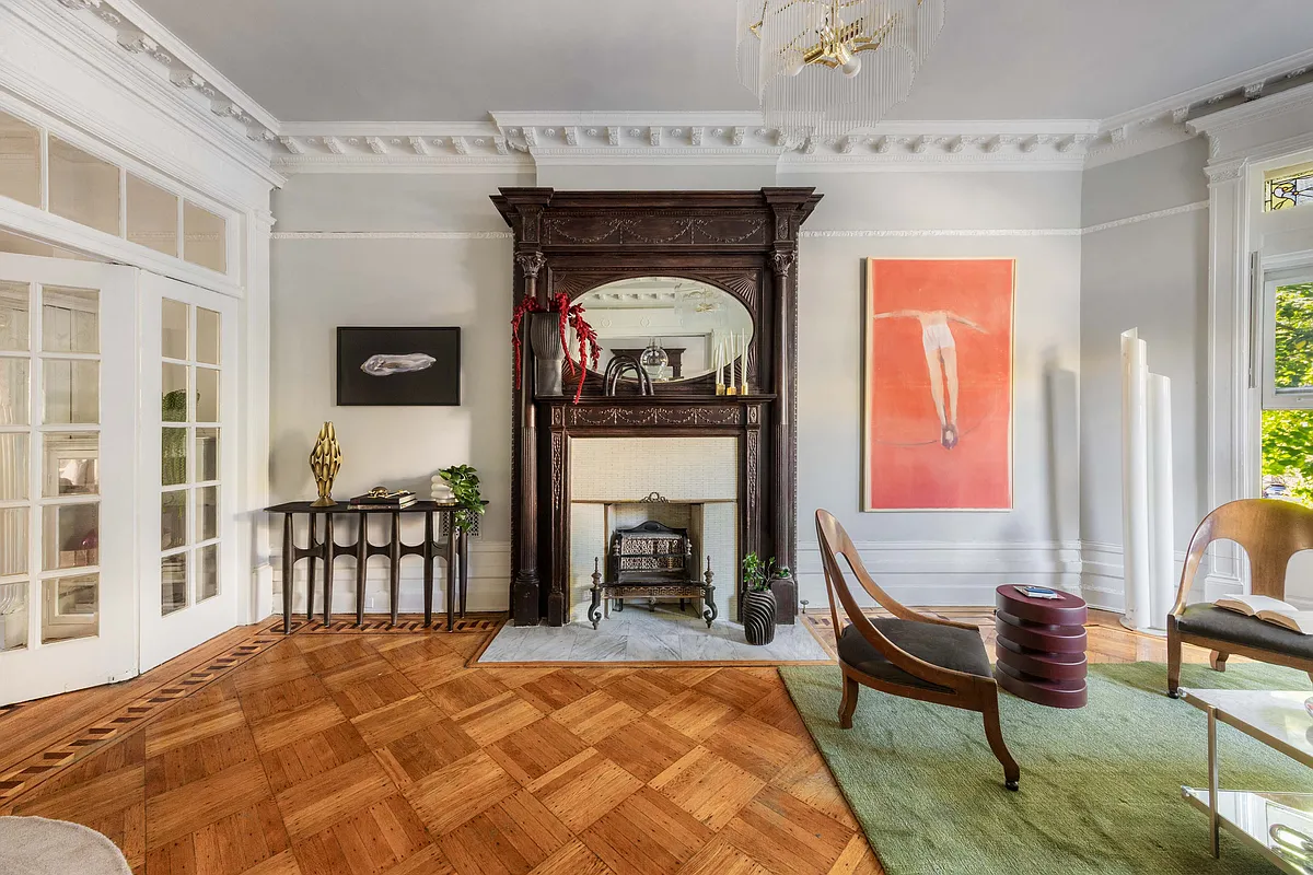 parlor with mantel, wood floor, and french doors to dining room