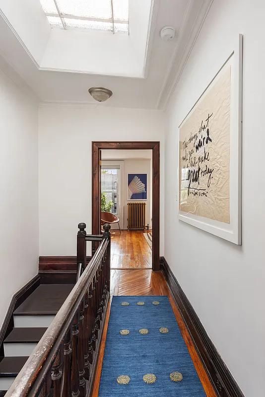 top floor hallway with skylight and view into a bedroom