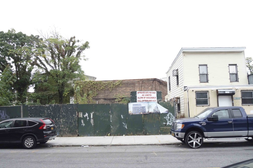 image of green construction fence and two story house