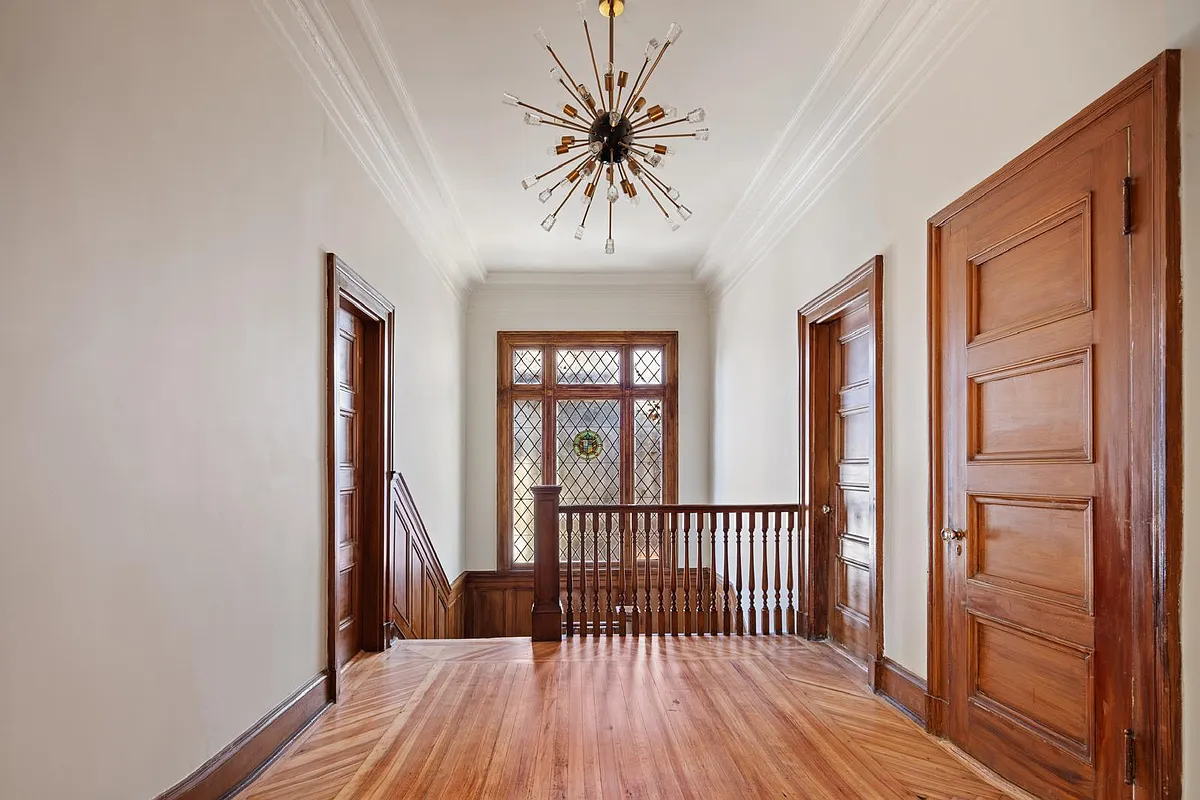 upstairs hall with wood floor, stained glass detail in leaded glass window