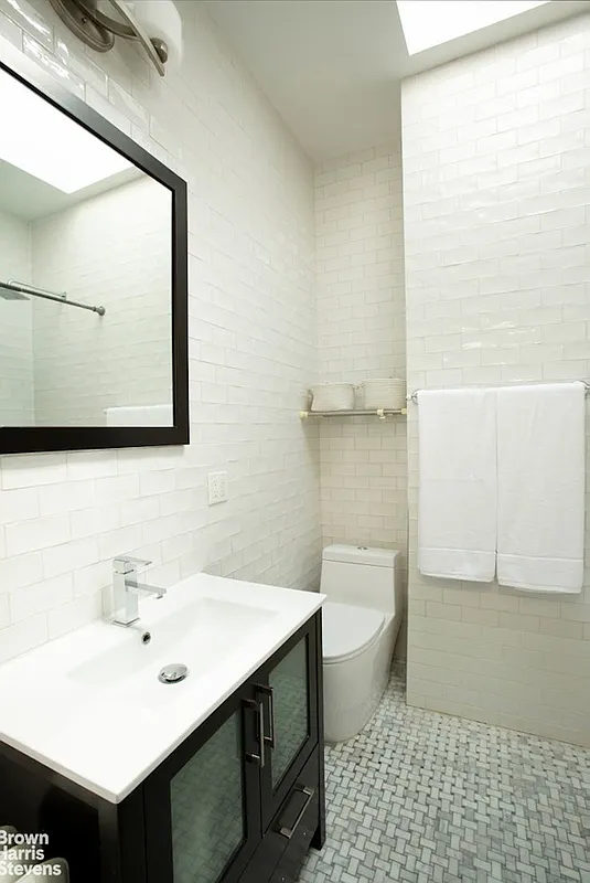 bathroom with skylight, black vanity